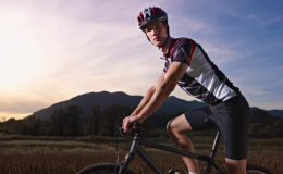portrait of man training on mountain bike at sunset